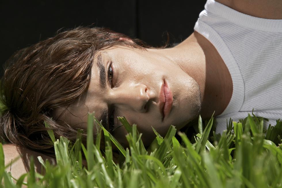 Young Man Lying on Grass - whitetag | iStockphoto