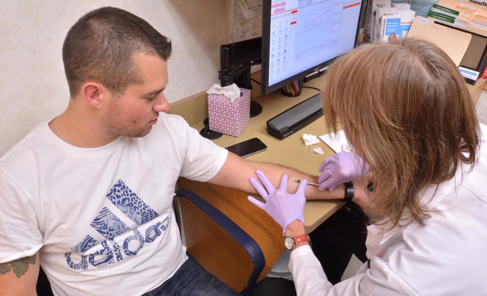 JERREY ROBERTS Connie Turner, who is a nurse practitioner, gives Christopher Meoli, of Northborough, a vaccination Wednesday at the CVS Minute Clinic on King Street in Northampton. - JERREY ROBERTS | DAILY HAMPSHIRE GAZETTE