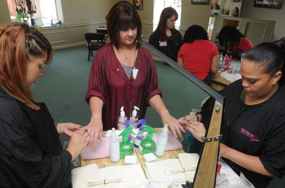 CAROL LOLLIS left, Abigail Cortes,19 of Holyoke and Laura Pantoja, 42 f Holyoke work on Nancy booth, director and instructor, nails while taking part in  a set of mock State Boards at  Kay Harvey Hair dressing Academy in West Springfield. - Carol Lollis | Daily Hampshire Gazette
