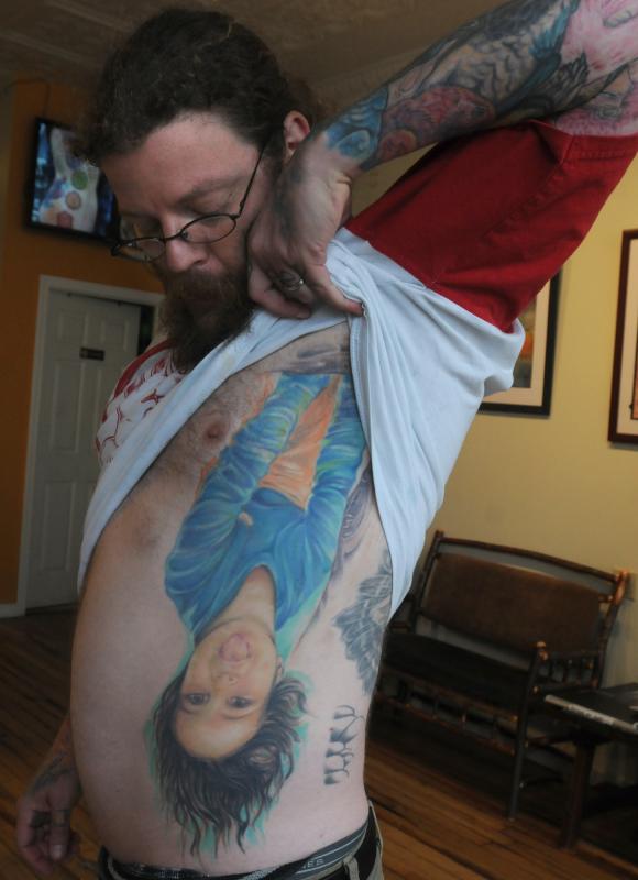 CAROL LOLLIS Gabe Ripley, owner of Off the Map tattoo, shows the tattoo of his daughter. - Carol Lollis | Daily Hampshire Gazette