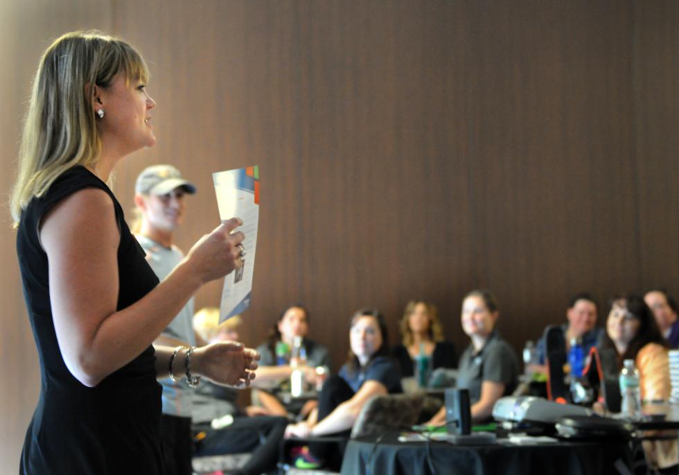 KEVIN GUTTING Maggie Baumer of Northampton, a business development associate with Hanger Clinic and a peer visitor coordinator at Amputee Empowerment Partners, speaks to health care workers at HealthSouth Rehabilitation Hospital of Western Massachusetts in Ludlow on Tuesday, October 6, 2015, prior to a motivational talk by Cameron Clapp, in background, of California about his experience as a triple amputee. - KEVIN GUTTING | DAILY HAMPSHIRE GAZETTE
