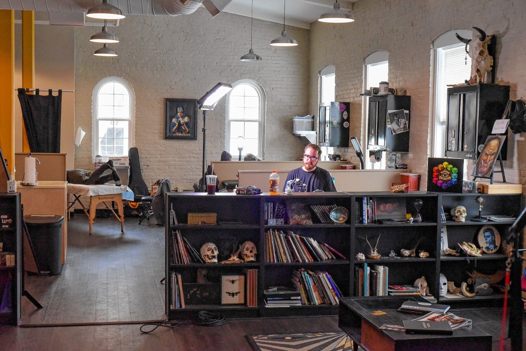 PETER VANCINIA tattoo artist works on a client at Off the Map's temporary second location in Easthampton's Button Building.