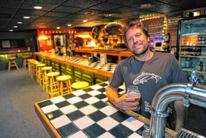 Wendell Rheinheimer, co-owner of the Root Cellar in Greenfield, with a special house beer by Stoneman Brewing. Photo: Paul Franz for the Recorder.