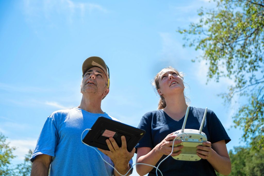 Gazette Staff/Andrew Whitaker—Andrew J. Whitaker/Gazette StaffJon Caris, left, watches the drone fly while Lizzie Sturtevan, right, controls the flight during the Spatial Analysis Lab flight demonstration at Smith College's Macleish Field Station Tuesday, August 9, in Whately.