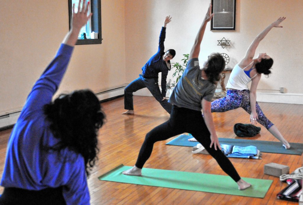 —GAZETTE STAFF / KEVIN GUTTINGJacoby Ballard leads an early morning class Friday at Yoga Center Amherst.