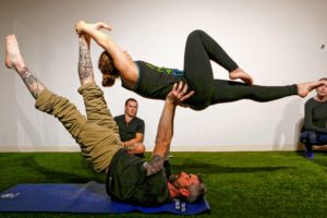 Jason Potash of Northampton, center, watches as Hampshire College student Elizabeth Levick and Brian Begley of Pittsfield perform a counterbalance March 31, 2017 during an acroyoga meet up at Mill 180 Park in Easthampton.