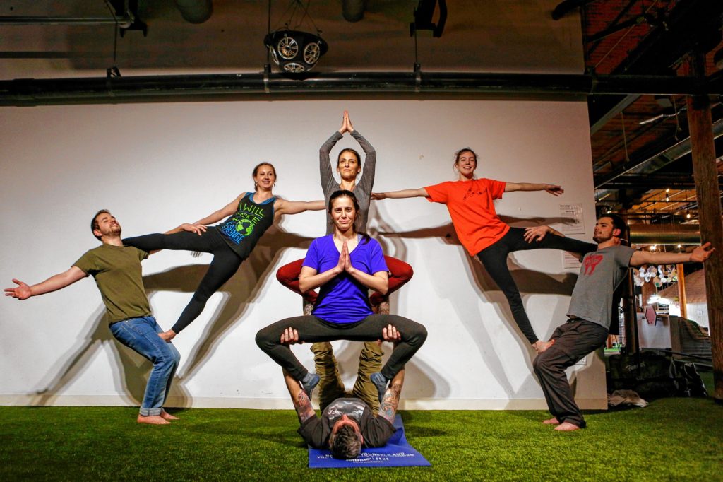 From left, Etai Dvora of Northampton, Hampshire College student Elizabeth Levick, Dorin Ben-Ami of Northampton, top center, Eliana Bronstein of Northampton, Brian Begley of Pittsfield, Hampshire College student Abbi Wilson and Will Witecki of Newington, Conn., perform a group pose March 31, 2017 during an acroyoga meet up at Mill 180 Park in Easthampton.