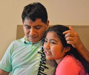 Lucio Perez, of Springfield, who is an undocumented immigrant who was facing deportation until he took refuge at First Congregational Church of Amherst Oct. 18, listens as his daughter, Lucy, 8, talks about how she misses seeing him, Saturday at the church.