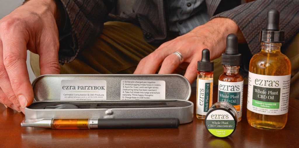 Ezra Parzybok displays his CBD products at his home office in Northampton.