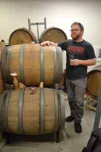 Sean Nolan, co-owner and brewer at Honest Weight Artisan Beer, checks the barrel cellar at the brewery in Orange. Hunter Styles photo.