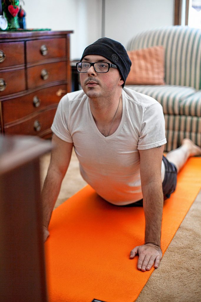 Rob Kelley of South Hadley begins his day with a yoga routine at home via an application on his phone.