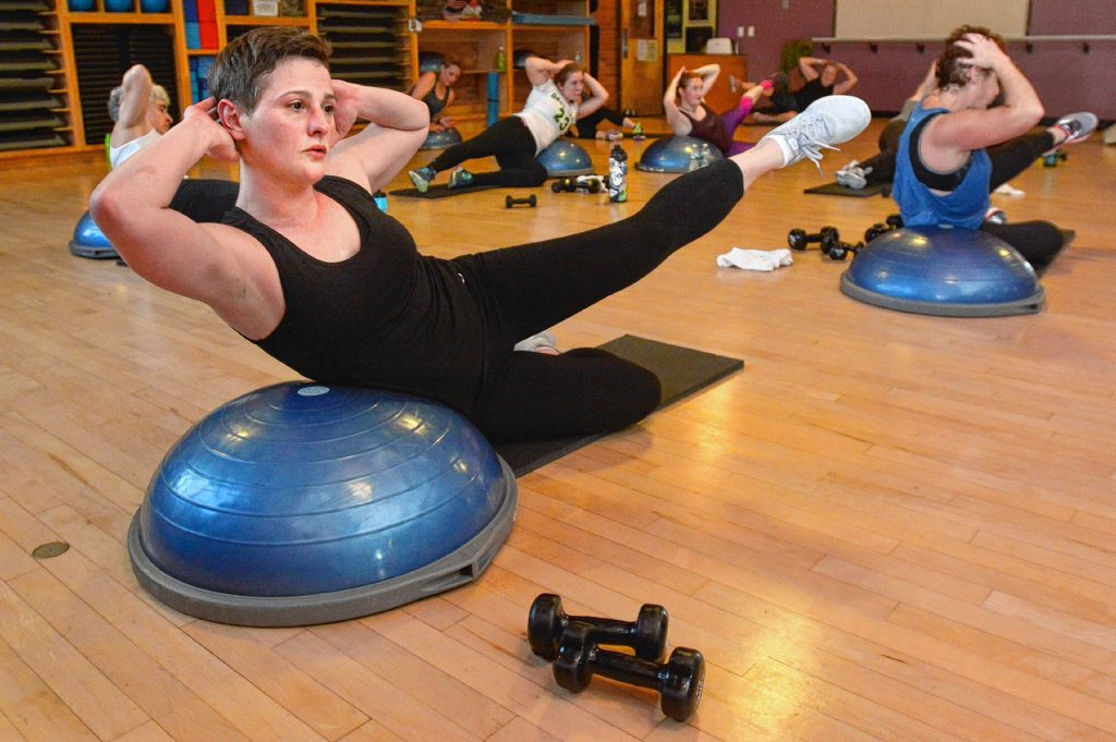 Christy Crutchfield, front, and others work their core muscles during Zawacki’s high intensity interval training class  at Northampton Athletic Club.