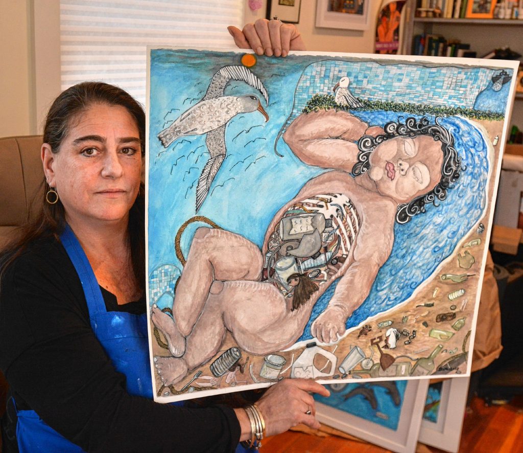 Artist activist Dara Herman Zierlein talks about plastic waste while displaying one of her paintings, Thursday, Jan. 31, 2019 at her studio in Northampton.