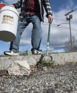 John Coughlin uses what he calls his "nipper nabber" to pick up empty discarded 50 ml single-use plastic bottles of liquor not far from his home in Agawam on Wednesday, April 10, 2019.