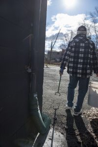 John Coughlin uses what he calls his "nipper nabber" to pick up empty discarded 50 ml single-use plastic bottles of liquor not far from his home in Agawam on Wednesday, April 10, 2019.
