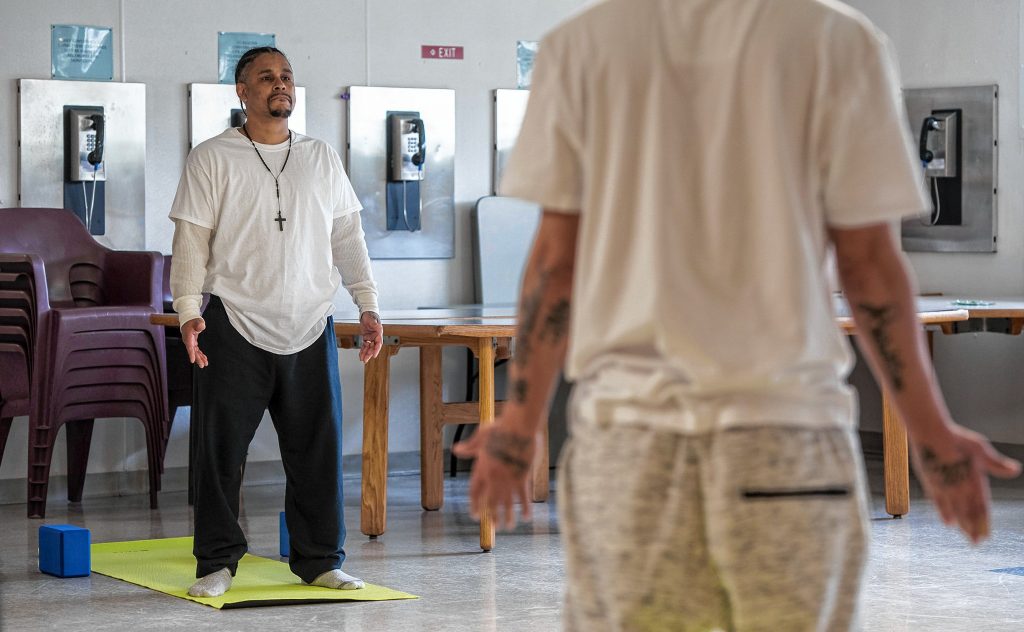 Steven, left, and Johnny, inmates at the Hampden County Pre-Release Center in Ludlow, take part in a yoga class in the Cultivating, Honoring and Awakening Men's Potential program, or CHAMP, on Tuesday, April 30, 2019.