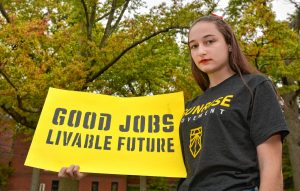 Kala Garrido, a Hampshire Regional High School student who is involved in the climate activist group Sunrise Northampton, holds a sign at Forbes Library, Wednesday, Oct. 16, 2019.