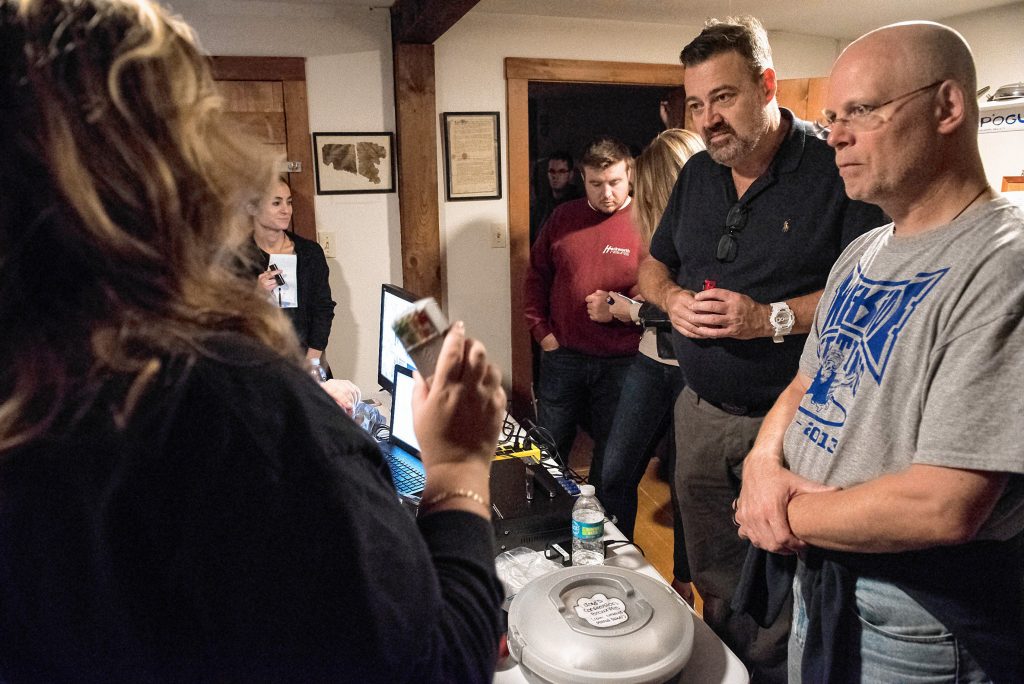 Steve Svec, right, and Dave Desmond listen as Liette Casey of Agawam Paranormal explains how to use a handheld detection device that each of the participants in the investigation will carry during an investigation at the Josiah Day House in West Springfield on Saturday evening, Sept. 14, 2019.