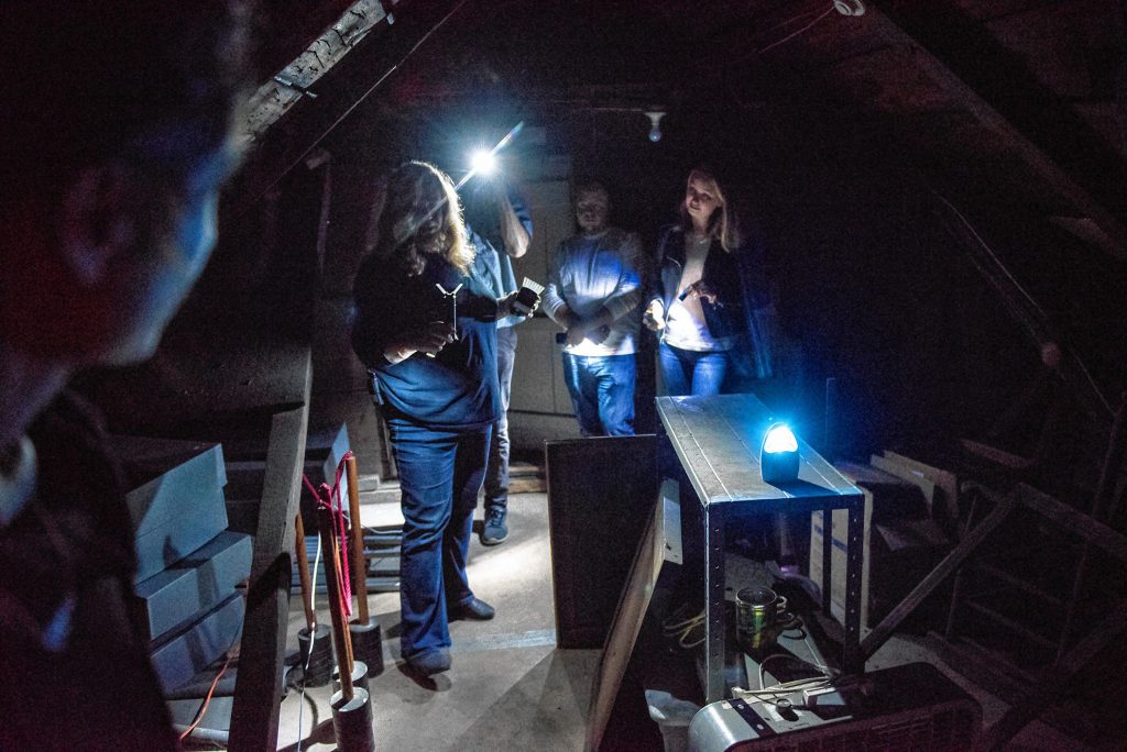 Liette Casey, left, with Agawam Paranormal holds two different detection devices as she leads an investigation in the attic of the Josiah Day House in West Springfield on Saturday evening, Sept. 14, 2019.