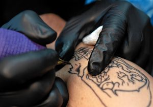 Eric Talbot works on a tattoo for Matt Miller at Oxbow Tattoo in Easthampton.