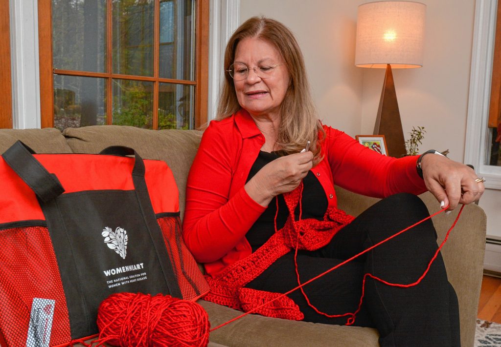 Lynette Bloise, who has become a WomenHeart champion, crochets a scarf at her home in Pelham.