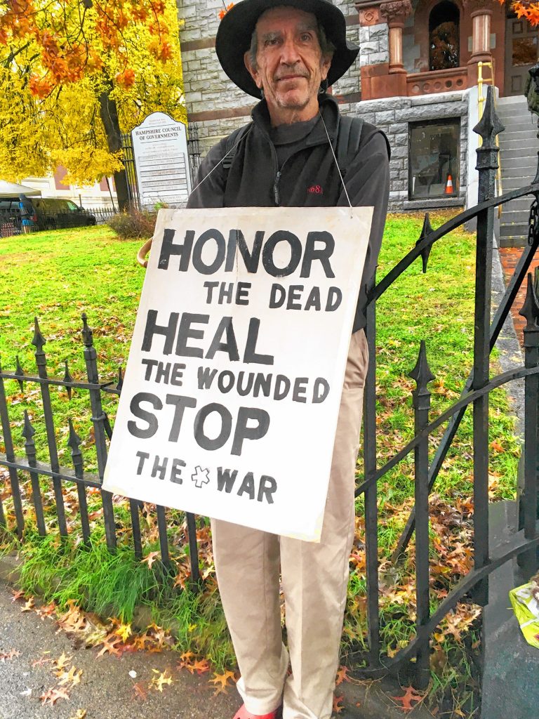 Andrew Larkin with his sign. It reads “Honor the dead / Heal the wounded / Stop the war.”