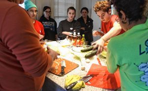 Jax Padilla, Rafaella Fabrizi, Joelle Bueno, and Zulay Holland watch along with others in a pupusa-making event, a collaboration between the Trans Asylum Seeker Support Network and a UMass Amherst anthropology class taught by Meredith Degyansky and Boone Shear. Natty demonstrates how to make pupusas.