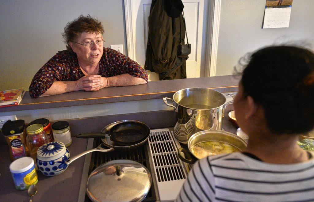 Lynne, left, talks with a woman she has given asylum to as she makes dinner in her kitchen, Thursday, Jan. 30.