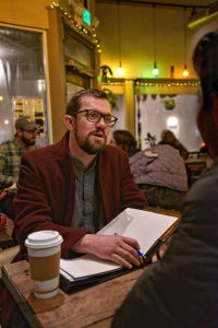 Jonathan Jenner, who is a volunteer for Western Massachusetts Asylum Support Network, talks with a client, Thursday, Feb. 13, 2020, at The Roost in Northampton.