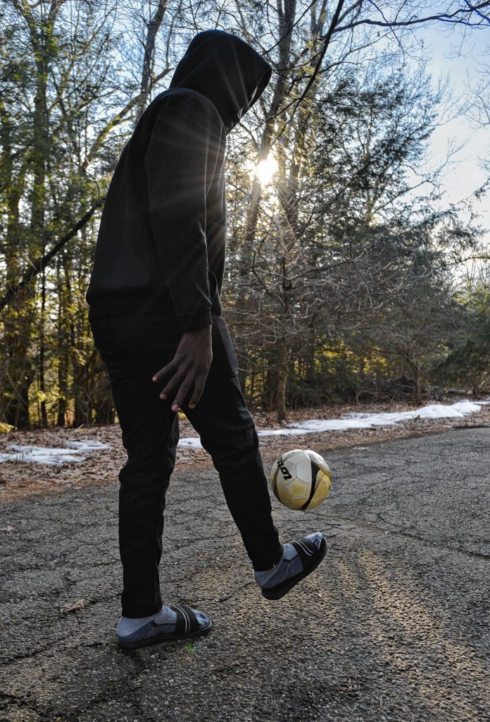 A man from west Africa who has received asylum status dribbles a soccer ball, Monday, Feb. 3, 2020.
