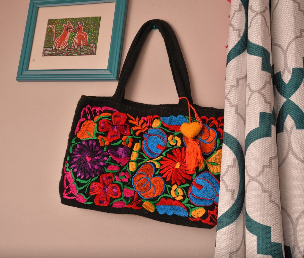 An embroidered handbag given to Natty is hung on a wall in her room at the home of her sponsor, Friday Mar. 6, 2020.