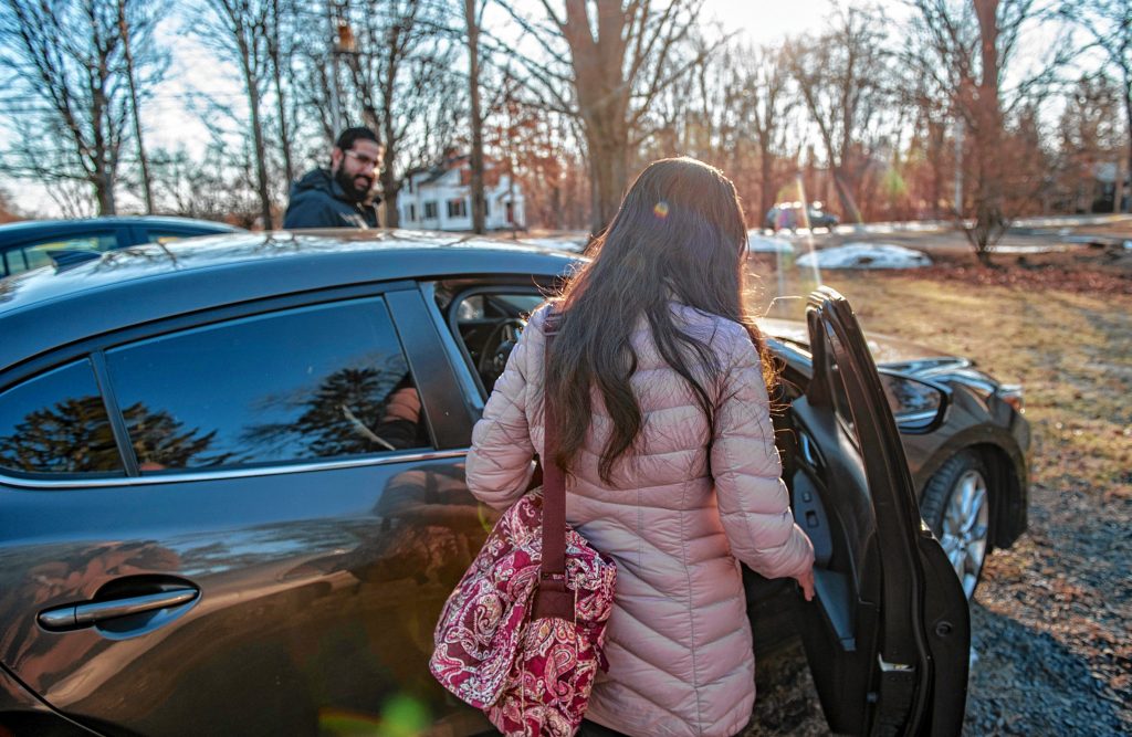 A woman in the process of seeking asylum gets a ride to the Immigration and Customs Enforcement office in Hartford from Osman Keshawarz, left, a volunteer with the Western Massachusetts Asylum Support Network.