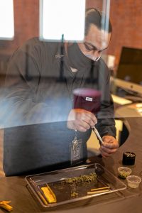 Steven Robles, of Northampton, packs a prerolled cone during a joint-rolling demonstration April 18 at Turning Leaf Centers dispensary in Northampton.