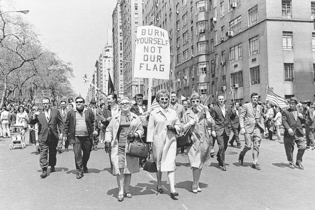Demonstrators marching at a “Patriot Parade” carry flags and banners to show opposition to the anti-Vietnam War demonstrators, New York City, 1967.