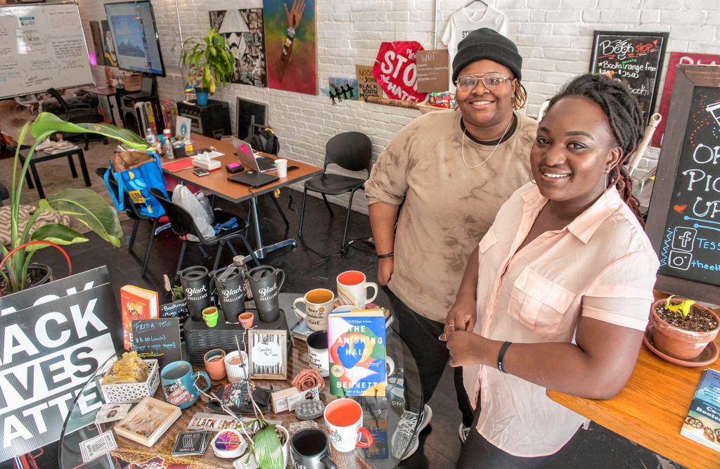 Stephany Marryshow, left, and Simbrit Paskins are co-owners of The Ethnic Study CoWork Cafe & Bookstore in Springfield which features work by local artists. Behind them, at left, are two paintings by Erika Slocumb. The café is a brick-and-mortar haven for where marginalized people can hang out, paint and learn in a safe environment. Photographed on Friday, Feb. 11.