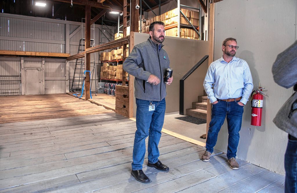 Volkan Polatol, left, and Kevin Perrier pause to talk in the sally port of their Easthampton warehouse, once a working barn for the former Underwood Farm, on Friday. The sally port, basically a large garage, allows delivery vehicles to be loaded and unloaded in a secure space, a requirement of the Cannabis Control Commission.