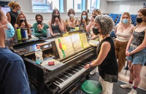 Beau Flahive, the longtime fine and performing arts teacher at Northampton High School who’s retiring in June, leads a warmup in the Little Theater for The Northamptones, the school’s a capella group that she started about 20 years ago.