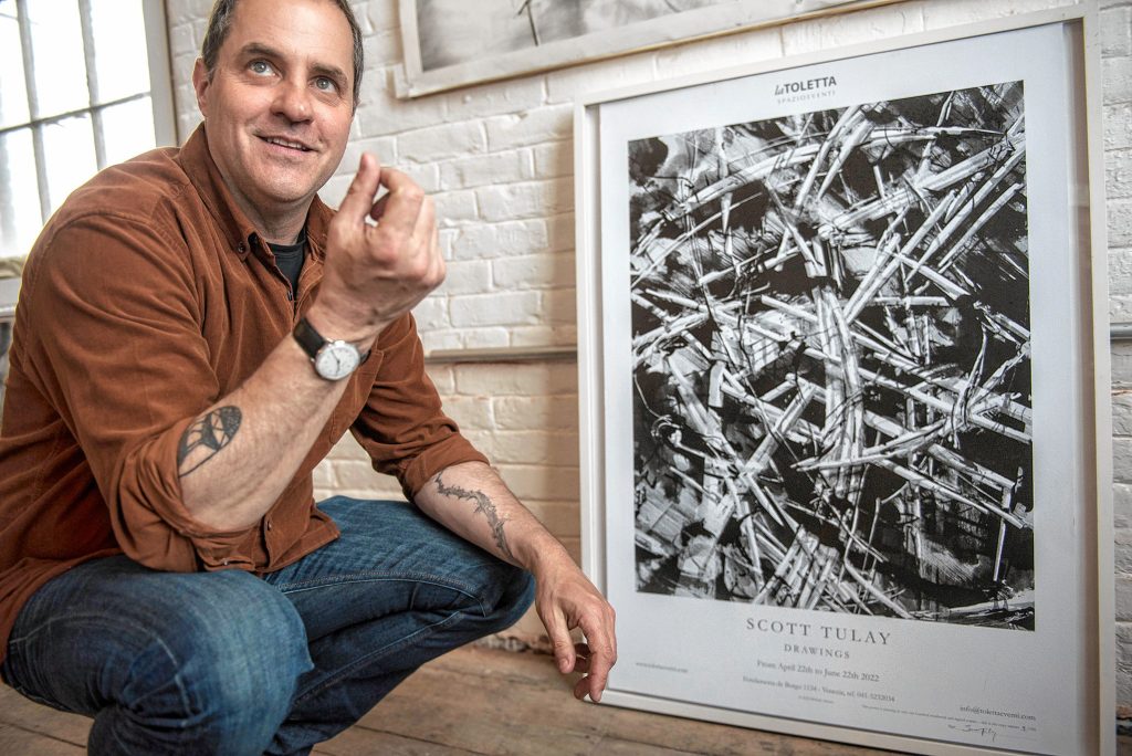 Northampton artist and architect Scott Tulay talks about his drawing process by a poster of his current show in Venice, Italy. 