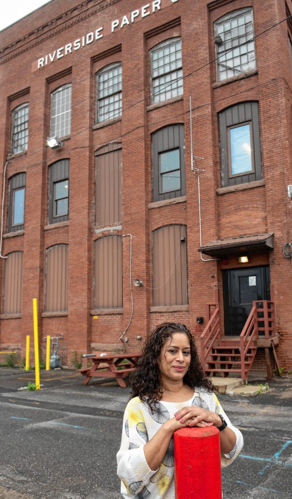 Damaris Aponte, owner of Blossom Flower Cannabis Delivery, stands in front of the building on Cabot Street in Holyoke where her business will be located.