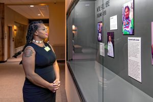 Aprell May stands next to her guest curated exhibit "We're Still Here," in the Native American Hall at the Springfield Science Museum.