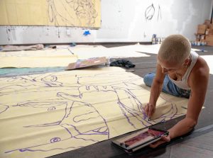 Mimi Ditkoff works on a mural for Commonwealth Murals and Out Now, a queer youth organization, at a studio in Springfield.
