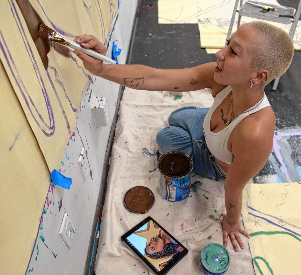 Mimi Ditkoff works on a mural for Commonwealth Murals and Out Now, a queer youth organization, at a studio in Springfield.