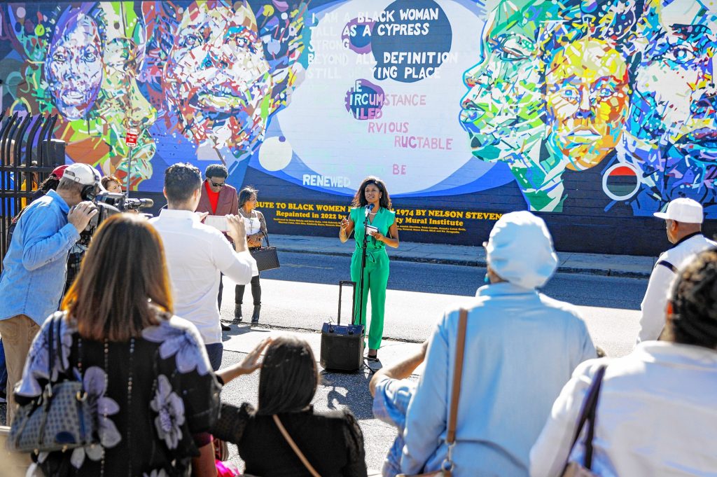Nadya Stevens speaks Saturday afternoon during the commemoration ceremony of the Tribute to Black Women mural, originally created by her father Nelson Stevens in 1974, that was recreated by Common Wealth Murals and the Community Mural Institute and is now on view at 38 Catherine Street in Springfield.