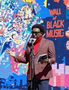 Andrew Cade speaks Saturday afternoon during the commemoration ceremony of The Wall of Black Music mural, originally created by Nelson Stevens with his student Clyde Santana, that was recreated by Common Wealth Murals and the Community Mural Institute and is now on view at 1 Montrose Street in Springfield.