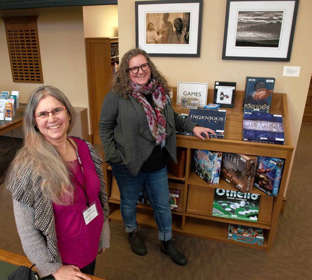 Faith Kaufman, head of Art and Music and Katy Wight, board member at Forbes library, stand with artwork by Julius Lester.