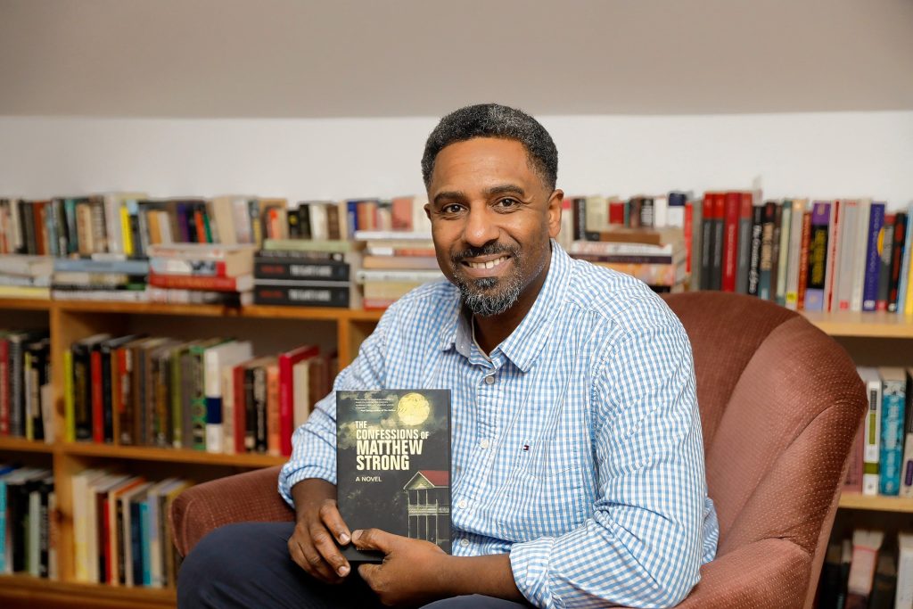 Ousmane Power-Greene with his debut novel, “The Confessions of Matthew Strong,” at the David Ruggles Center in Florence, where he’s often presented talks on Black history.