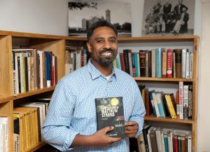 Ousmane Power-Greene with his debut novel, “The Confessions of Matthew Strong,” at the David Ruggles Center in Florence, where he’s often presented talks on Black history.