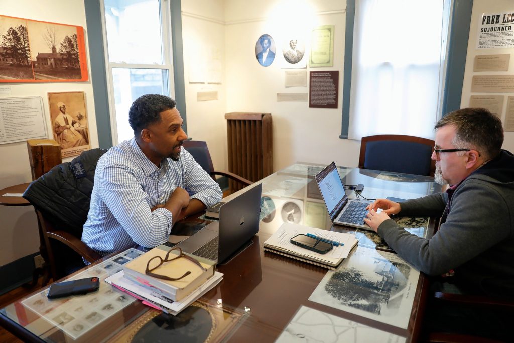 Ousmane Power-Greene, left, and independent educator Michael Lawrence-Riddell have a discussion in the Sojourner Truth room at the David Ruggles Center in Florence.